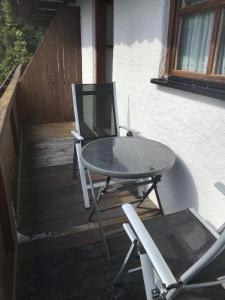 una mesa y sillas en una terraza de madera en Rachel, en Hauzenberg