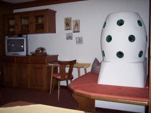 uma sala de estar com uma cadeira e uma televisão em Gästehaus Bruggerhof em Längenfeld