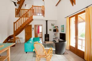 a living room with a staircase and a blue couch at Domaine de Gayfié in Salvagnac-Cajarc