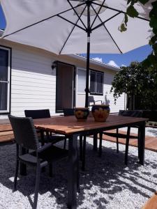 una mesa de madera con una sombrilla en el patio en De Krukel, en Sint Annaland