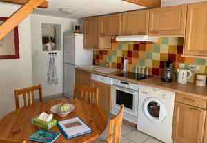 une cuisine avec une table en bois et une cuisine avec un lave-linge dans l'établissement La Forge - Gordes, à Gordes