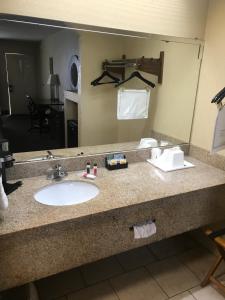 a bathroom with a sink and a large mirror at Super 8 by Wyndham Monroe in Monroe