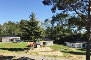 - une vue sur deux maisons blanches arborées dans l'établissement LouisaPark, à Łagów