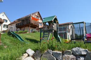 un parque infantil en un patio con una casa en Chambres d'hôtes Les vignes en Saint-Jean-Saverne