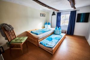 1 Schlafzimmer mit 2 Betten, einem Stuhl und einem Fenster in der Unterkunft Hof Bergidyll in Bürberg