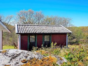 uma pequena casa vermelha sentada em cima de um campo em 7 person holiday home in HAKEN SET em Berga
