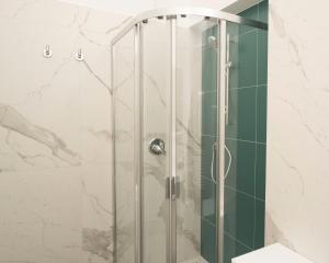 una doccia con porta in vetro in bagno di Civico 43c a Porto San Giorgio