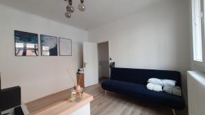 a living room with a blue couch in a room at Joli T2- centre ville - Parking gratuit - WIFI in Dunkerque