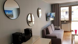a living room with a couch and a mirror at Apartament Opal Zdrojowa 300m do morza in Świnoujście