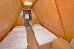 - 2 lits dans une petite chambre avec des murs en bois dans l'établissement Finnhütten Waldesruh, à Lochow