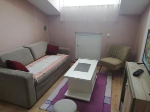 una sala de estar con un sofá y una mesa en Apartman M, en Soko Banja