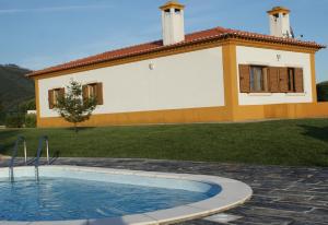 a house with a swimming pool in front of a house at Casa da Eira em Dornes - Casa de campo familiar com piscina in Dornes