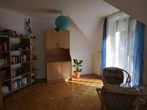 a room with a table and a chair and book shelves at Apartma Juteršek in Libeliče