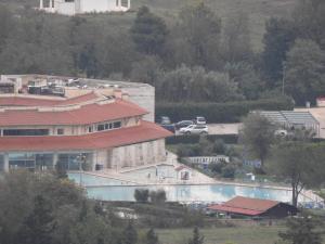 a building with a swimming pool and a parking lot at B&B Il Giardino Etrusco in Saturnia