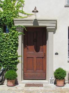 een houten deur van een huis met twee potplanten bij Le Maddalene B&B in Avigliana