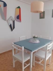 una mesa azul con 2 sillas blancas y una lámpara en Apartamento Nuit, en Teruel