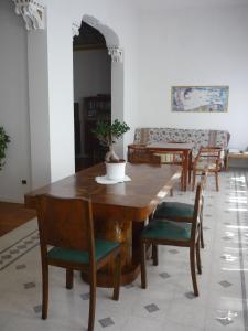 comedor con mesa de madera y sillas en Il Giardino Segreto, en Imola