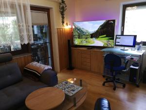 a living room with a desk with a computer and a tv at Ferienwohnung Krottensee in Gmunden