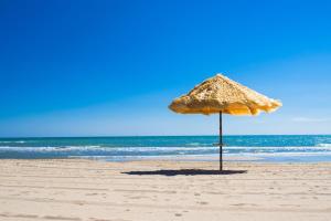 a straw umbrella sitting on the beach at La Rue in Tortoreto Lido