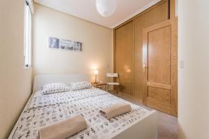 a bedroom with a white bed and a wooden door at Boutique Apartments in the Heart of Madrid in Madrid