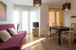 salon z fioletową kanapą i stołem jadalnym w obiekcie Bright Apartment in Hip & High Quality Neighborhood w Wiedniu