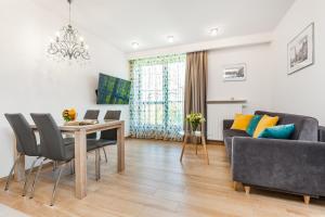 una sala de estar con una mesa y un sofá en Happy Stay OldNova Deluxe Apartment 366, en Gdansk