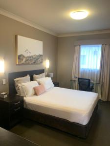 um quarto com uma cama grande e uma janela em Best Western Blackbutt Inn em Newcastle