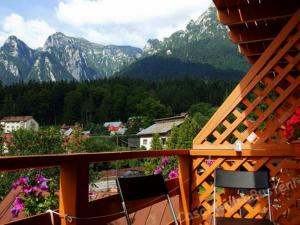 a balcony with two chairs and a view of mountains at Casa Magica Busteni in Buşteni