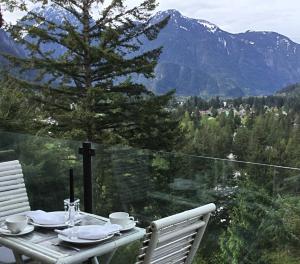a table and chairs on a balcony with a view of mountains at High Hopes Bed and Breakfast in Hope