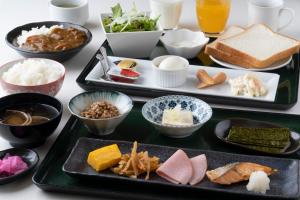 a table topped with two trays filled with food at Hotel Monzennoyu in Joetsu