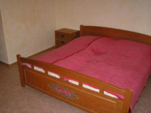 ein Schlafzimmer mit einem Holzbett mit einer roten Decke in der Unterkunft Domizil in Moosbach