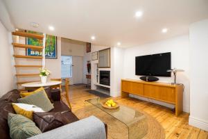 a living room with a couch and a flat screen tv at Beachside Loft St Kilda west in Melbourne +2 photos