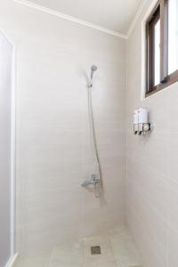y baño blanco con ducha y ventana. en Gold Coast B&B, en Huxi 76 fotos más