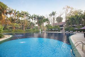 a swimming pool with blue water and palm trees at Mida Resort Kanchanaburi - SHA PLUS in Sai Yok