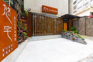 YZ SPA House في جياوكسي: مدخل لمبنى به زهور ونباتات