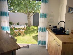 una cucina con vista su un cortile con un albero di Estrella a Les Sables-dʼOlonne