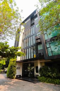 a building with a lot of windows and trees at BED Changkian - Adults Only in Chiang Mai