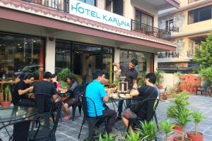 a group of people sitting at a table outside a restaurant at Hotel Karuna in Pokhara