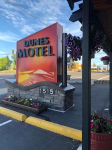 Una señal para un motel de dunas al lado de una calle en Dunes Motel - Bend, en Bend