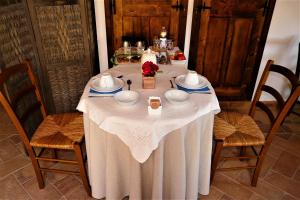 een tafel met een witte tafeldoek erop bij Casale Le Orme in Todi