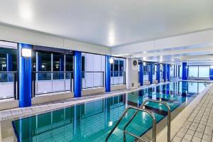a swimming pool with two chairs in a building at Horizons 1402 in Adelaide