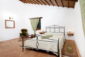 una camera con letto di metallo e tavolo di Casale Le Orme a Todi
