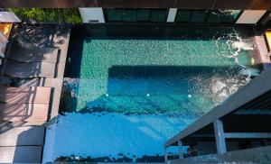 a swimming pool with blue water in a building at BED Chiangmai Gate- Adults Only in Chiang Mai