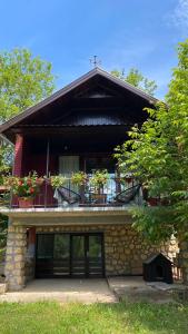 a building with a balcony with flowers on it at Agape Glamping in Velika Remeta