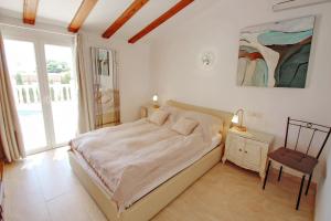 ein Schlafzimmer mit einem Bett und einem Stuhl darin in der Unterkunft Michelle - sea view villa with private pool in Benissa in Benissa