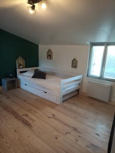 ein Schlafzimmer mit einem großen Bett und Holzboden in der Unterkunft maison "Le Goéland" à deux pas des plages in Longeville-sur-Mer