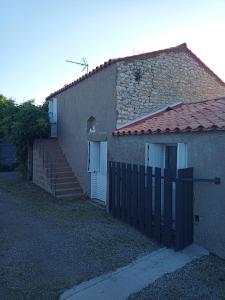 een gebouw met een poort en een deur en trap bij maison "Le Goéland" à deux pas des plages in Longeville-sur-Mer