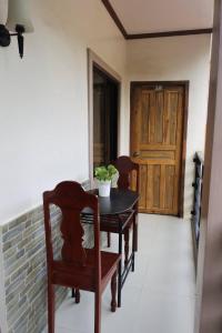 ein Esszimmer mit einem Tisch, Stühlen und einer Tür in der Unterkunft Sheryl May Inn in El Nido