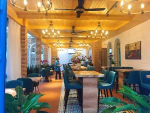 Turi Staypoint في كوانج نجاي: مطعم فيه طاولات وكراسي وناس في الخلف