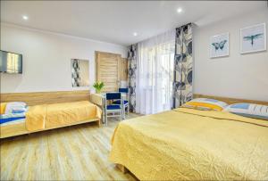 ブワディスワボボにあるPokoje u Irenyのベッド2台とデスクが備わるホテルルームです。